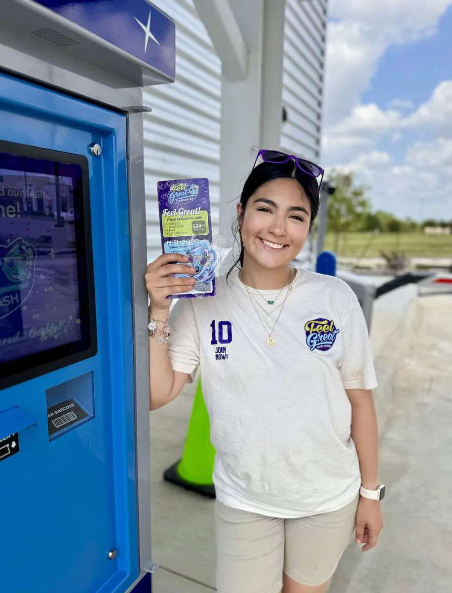 A Feel Great Car Wash Employee holding up some promotional material for the car wash