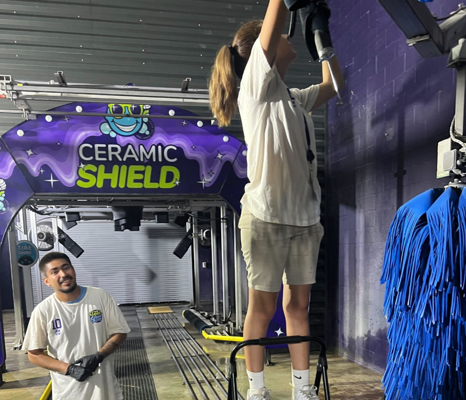 Employees working with cleaning equipment at Feel Great Car Wash